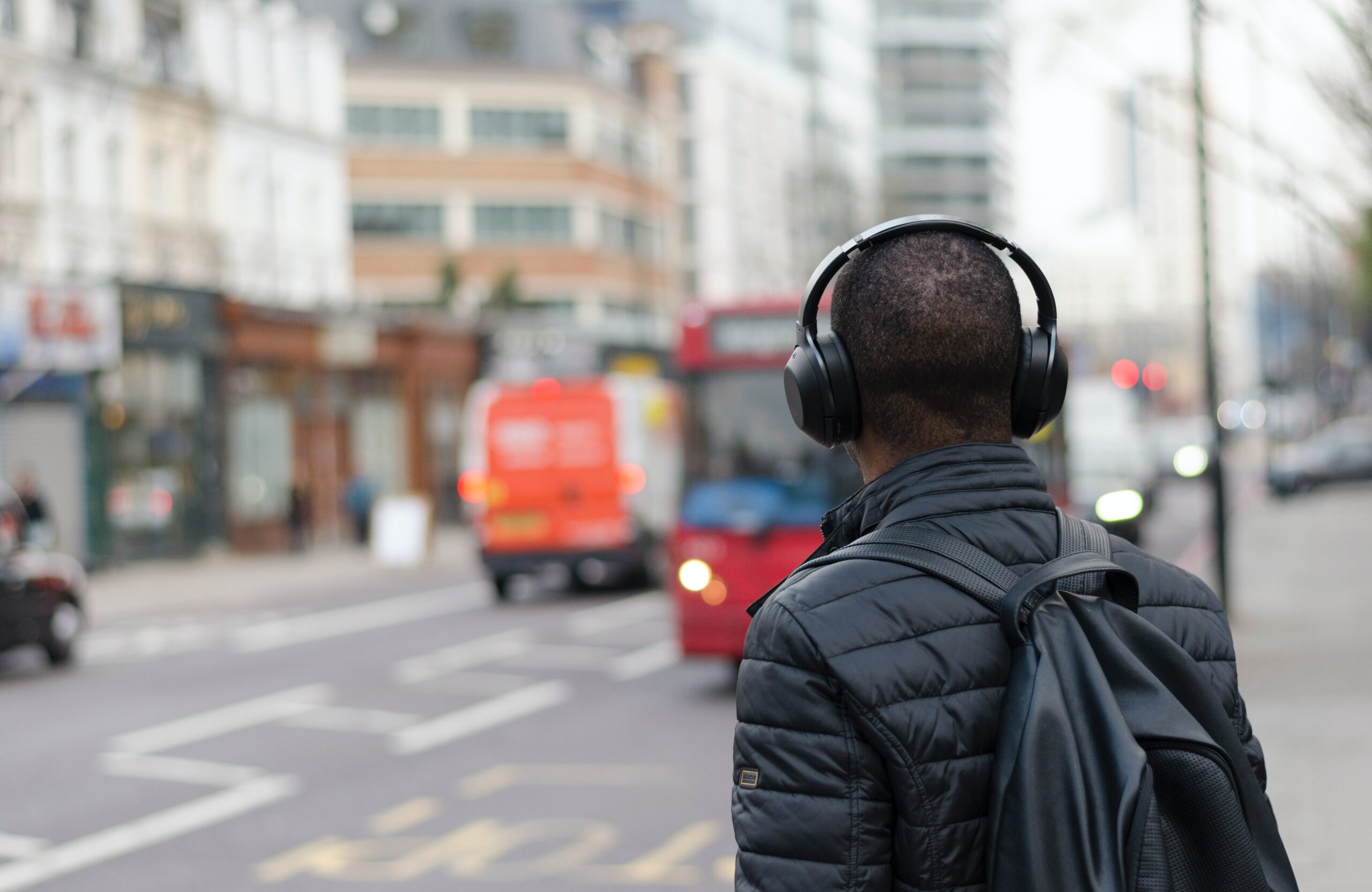 Person wearing headphones listening to a podcast on a city street